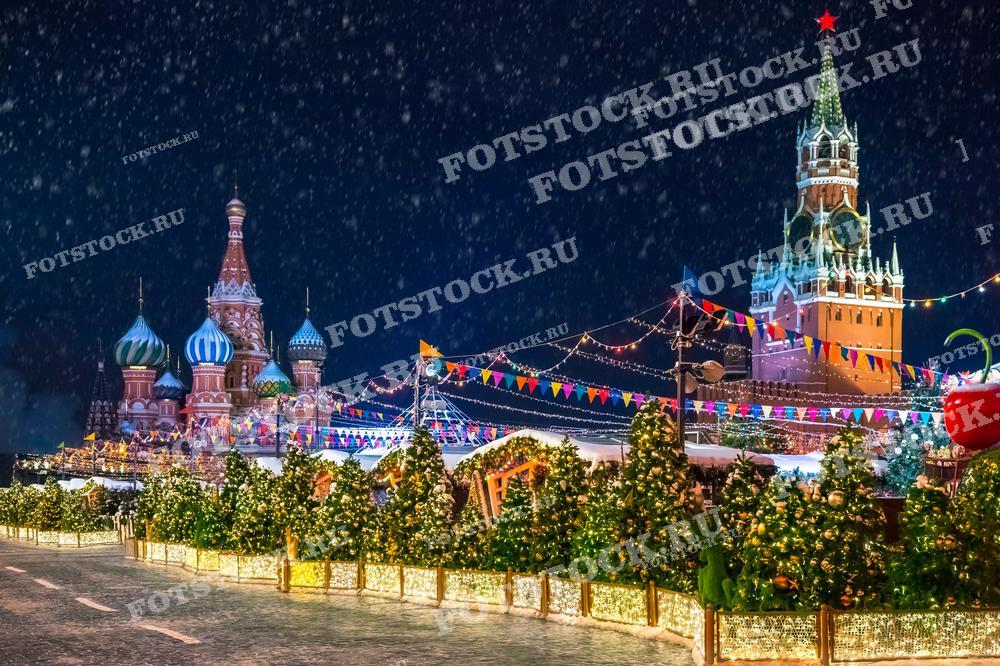 На этой фотографии представлена волшебная зимняя сцена Красной площади в Москве, украшенной к празднованию Нового года и Рождества. Видны Собор Василия Блаженного и Спасская башня, а также множество рождественских елок, украшенных гирляндами и огнями. Падающий снег добавляет атмосферы волшебства и праздника. Это изображение отлично подходит для использования в публикациях, посвященных зимним праздникам, в туристических брошюрах или в качестве иллюстративного материала для статей о российских традициях и культуре.